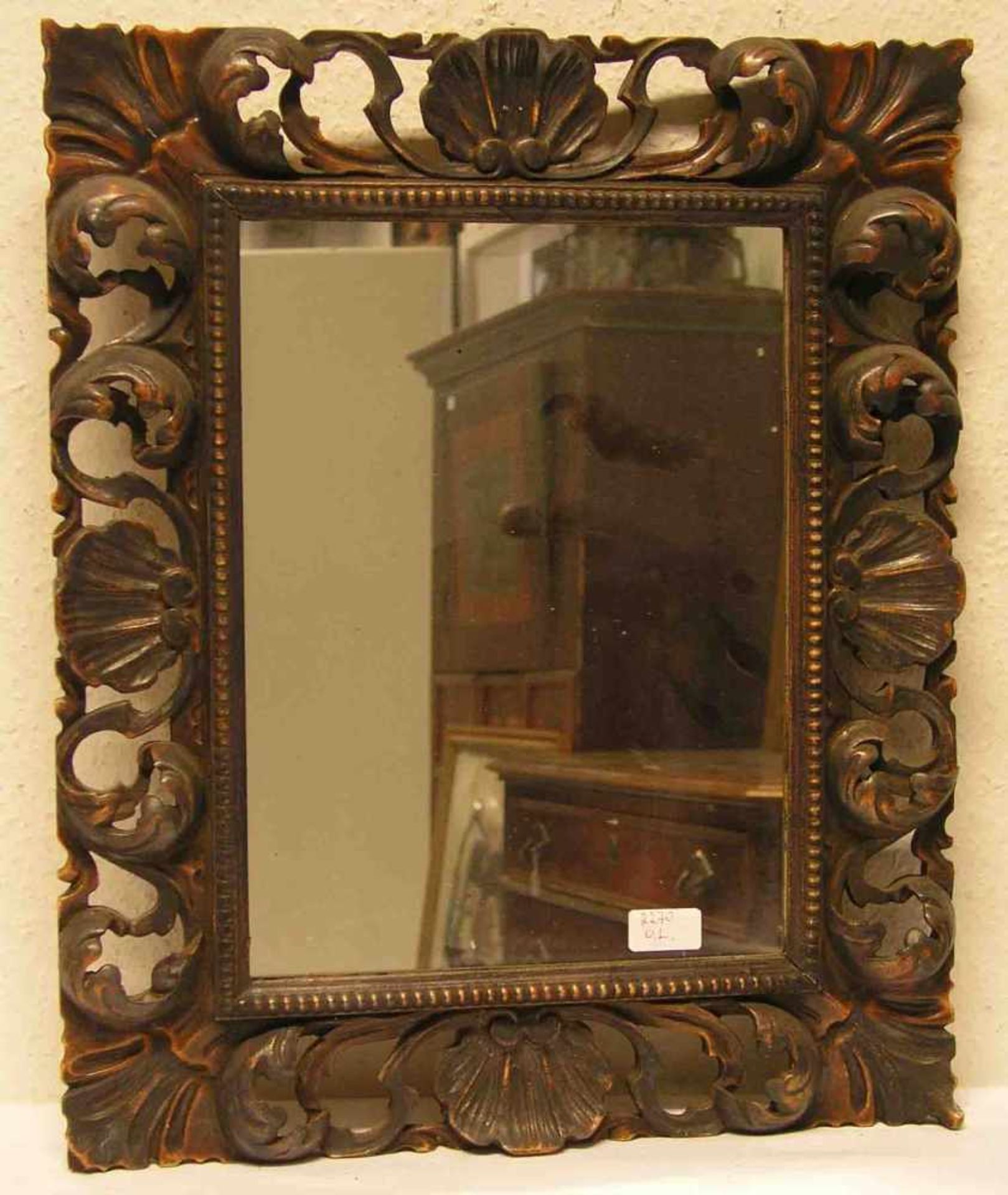 Spiegel im geschnitzten Holzrahmen. Gesamtmaße: 56 x 47cm.