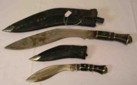Zwei Kukri Messer. Indien, beschädigt. Längen: 25 und 40cm. Lederetui.