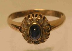 Damenring. Gold 8 kt. Zentral blauer Cabochon, umkreist von Diamantsplittern. Ringgröße:57. 3,2