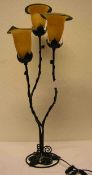 Tischlampe mit drei Brennstellen. Fuß aus Schmiedeeisen, Glasschirme in Blütenform. Höhe: