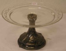 Fußschale um 1920. Reliefierter Fuß, geschliffene Glasschale, kleiner Chip. Höhe: 15,5cm.