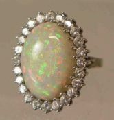 Opalring. 18 kt. Weißgold. Großer ovaler Ringkopf mit schönem Opal, ca. 8 ct., umkränzt