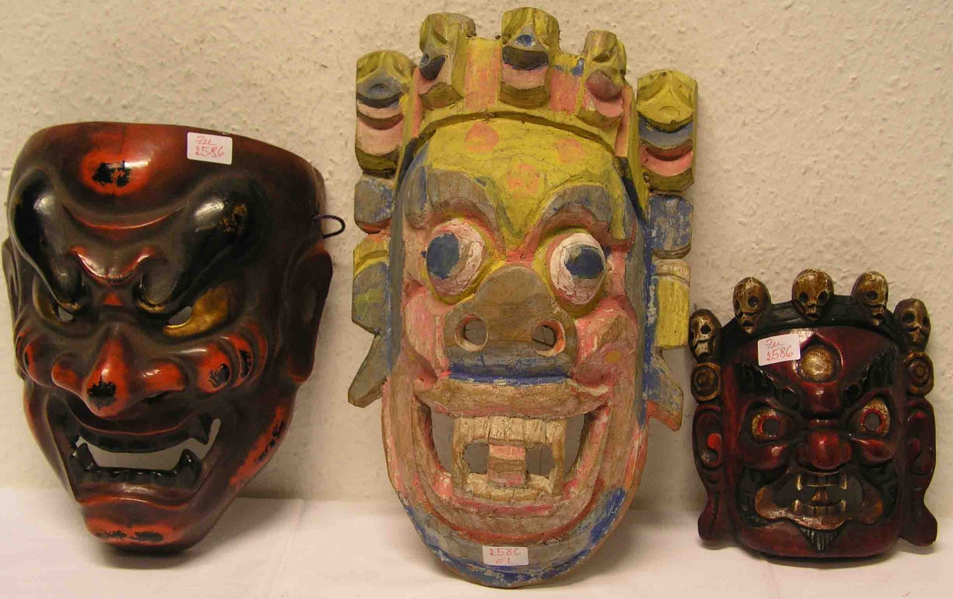 Posten von drei Masken. Dabei: zwei balinesische Masken aus leichtem Holz und eine