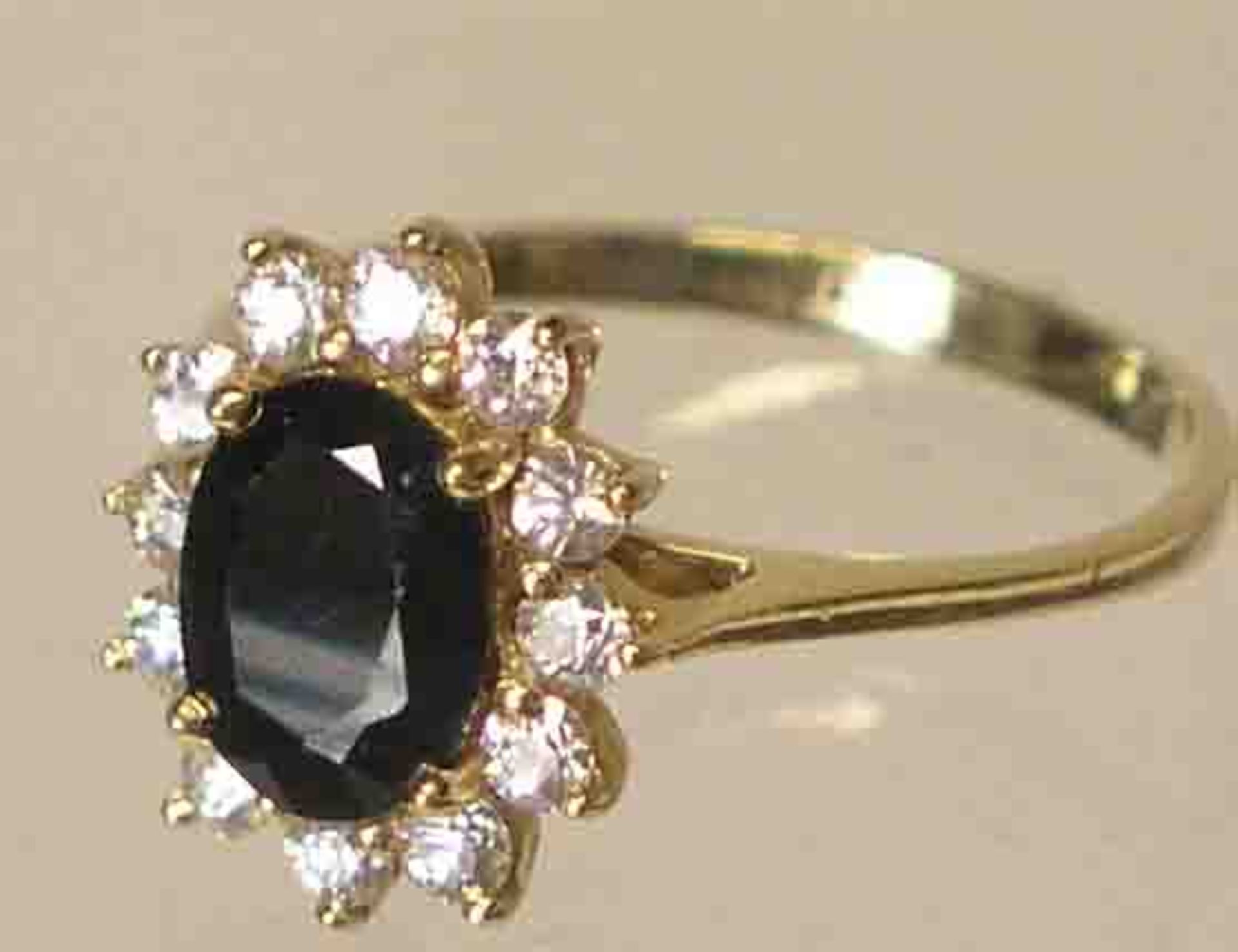 Saphir-Ring. 14 kt. Gold. Großer Ringkopf mit facettiertem Saphir, umgeben von 12