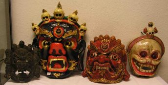Vier buddhistische Tanzmasken (wohl Tibet). Pappmaché gehärtet, bemalt. Höhen: 24 bis