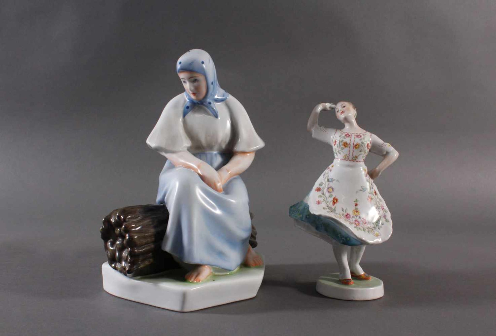 Porzellanfigur, Ungarn, "Tänzerin in Trachten" und "Bäuerin auf Reisigbündel sitzend"