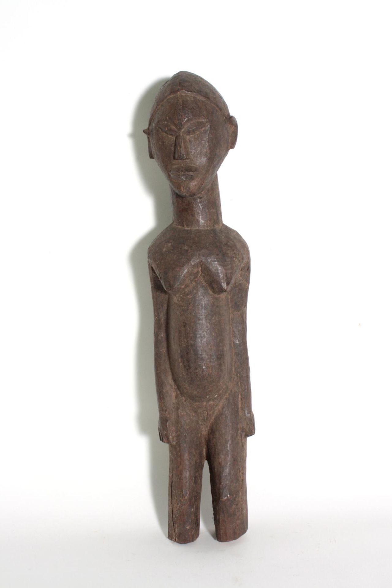 Stehende weibliche Figur, wohl Lobi, Burkina Faso. 1. Hälfte 20. Jh.Holz, dunkelbraune und