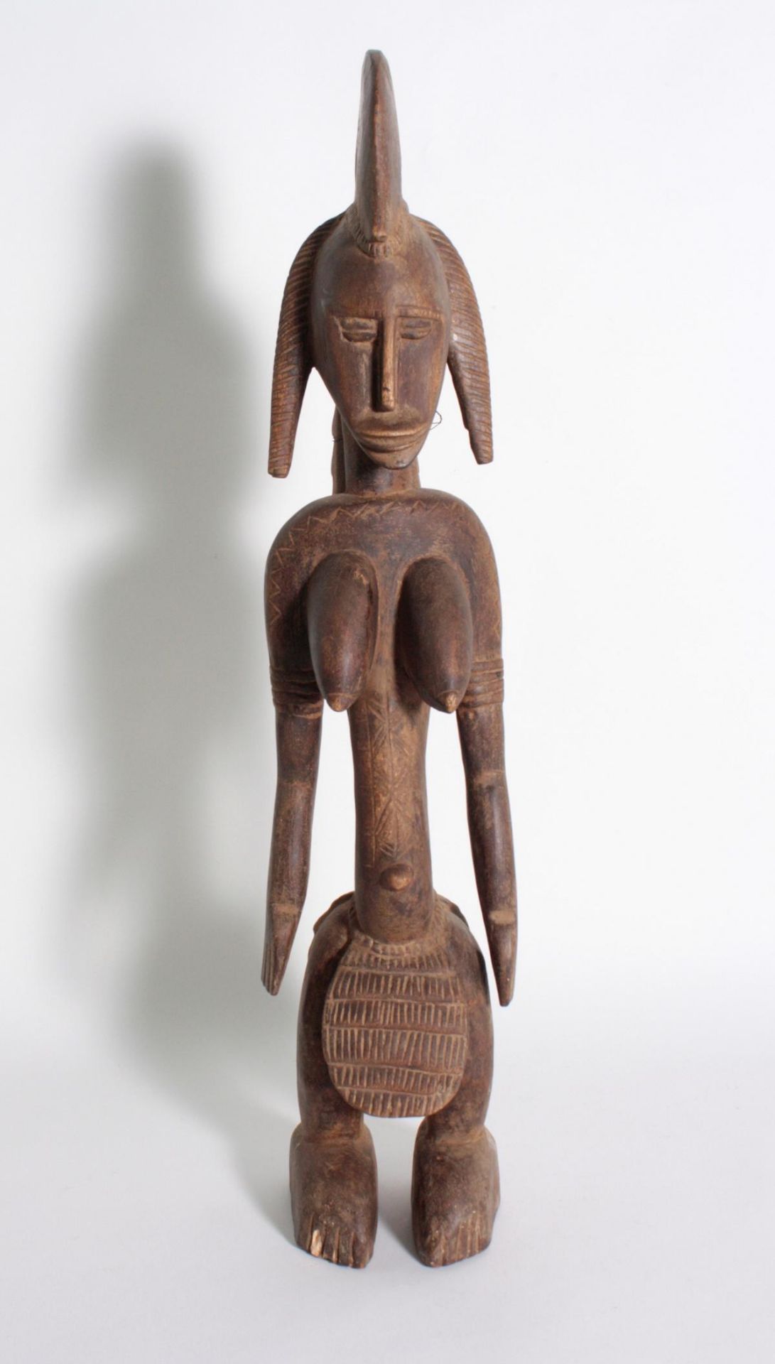 Stehende Frauenfigur, Senufo/Elfenbeinküste, 1. Hälfte 20. Jh.Bräunliches Holz. Stehende Frauenfigur