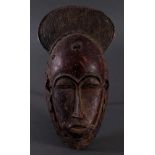 Antike Kpan-Maske, Baule, Elfenbeinküste 1. Hälfte 20. Jh.Holz  geschnitzt, dunkle Patina, rot
