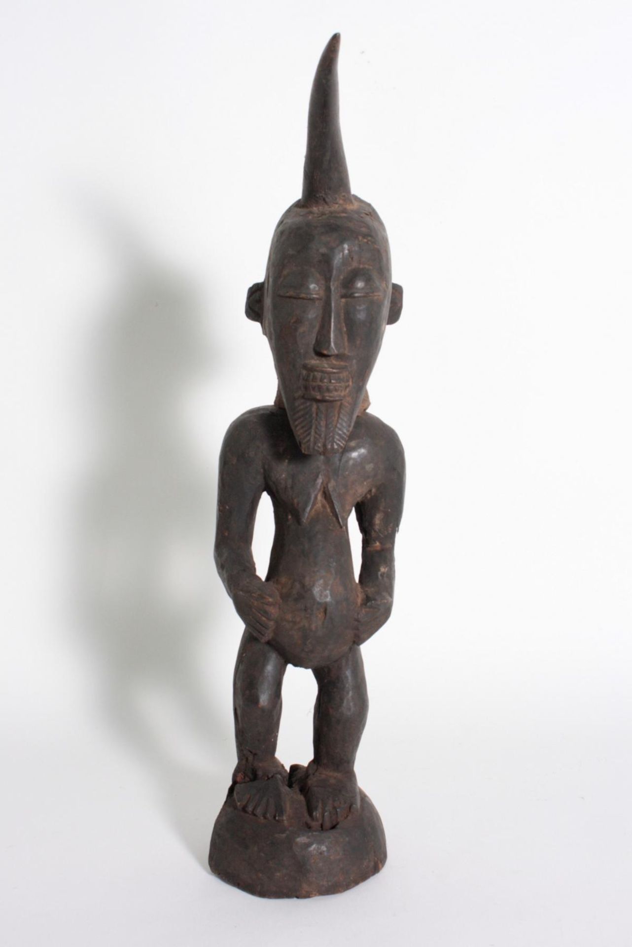 Kraft-Figur, Songye/Kongo, 1. Hälfte 20. Jh.Holz geschnitzt und dunkel patiniert, auf rundem