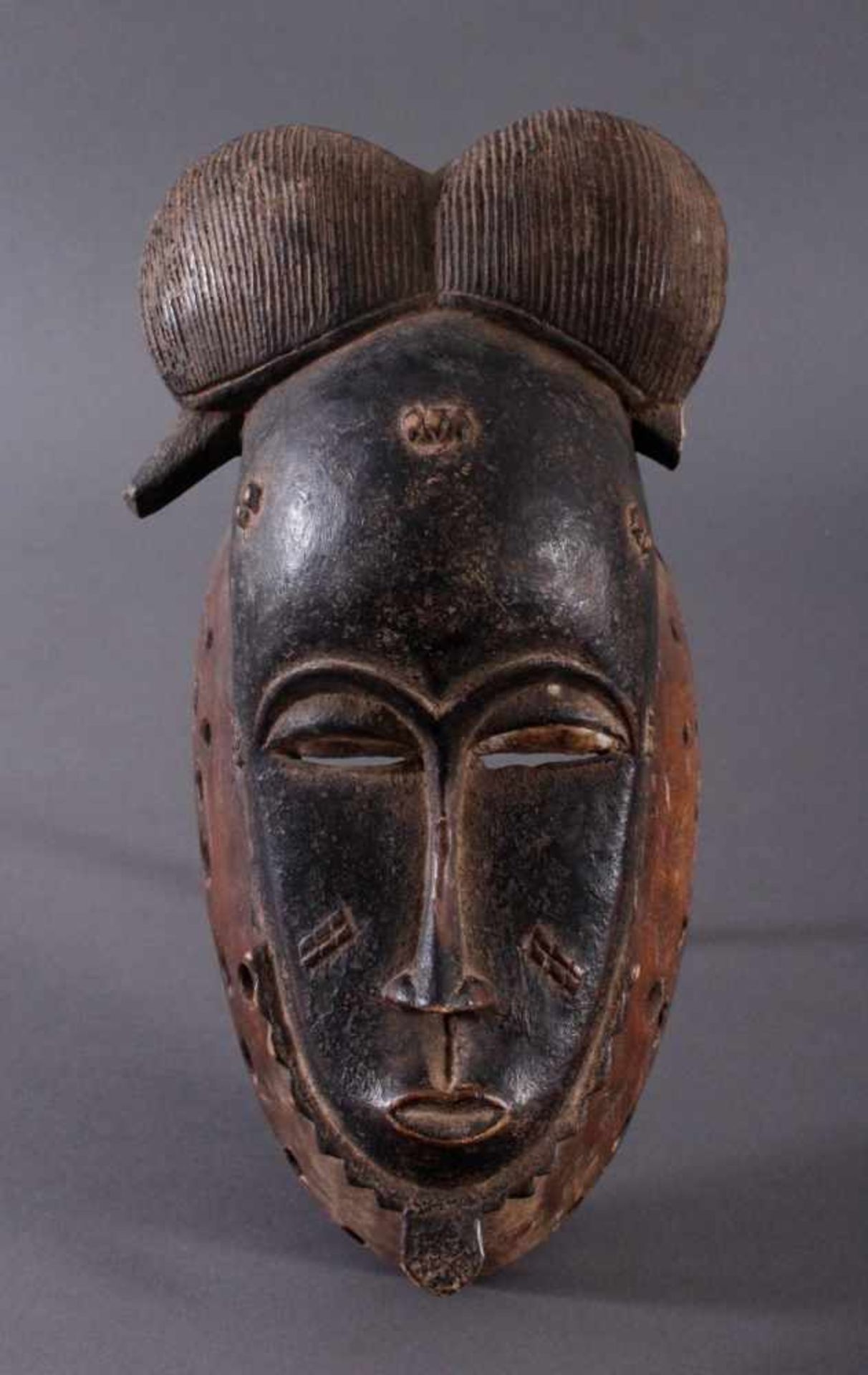 Antike Maske, Baule, Elfenbeinküste 1. Hälfte 20. Jh.Holz geschnitzt, dunkle Patina, Haar-Spitze