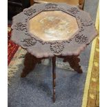 An early 20th century Burmese type shaped octagonal occasional table, profusely carved throughout,