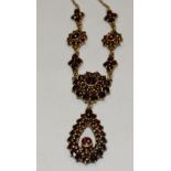 An Edwardian style red garnet pendant necklace, open pear drop droplet,