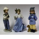 A Nao figure of a Young Girl with a puppy; another Boy in a Duffle Coat with a dog;