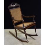 A late 19th, early 20th century century mahogany rocking chair, turned legs,