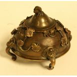 An Oriental bronze censor, applied with scrolling vines, the lid with butterfly finial,