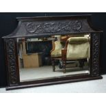 An early 20th century oak overmantel mirror, the rectangular plate flanked by carved serpents, 104.