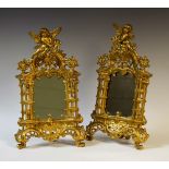 A pair of gilt framed mirror with putti playing lyre, marked Beatrice,