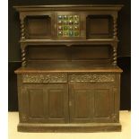 An Arts and Crafts period oak side board, stained glass panels, c.