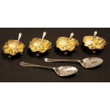 A set of four silver scallop shell table salts, gilded interiors, each resting on three ball feet,