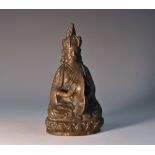 An Indian/Nepalese brown patinated bronze, of a deity, seated, holding cymbals,