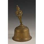 An Indian bronze temple bell, the handle cast as a deity, the side with figures and wild animals,