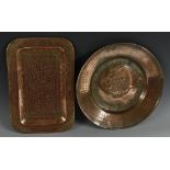 A Middle Eastern copper rounded rectangular dish, chased in the Islamic taste with Arabic script,