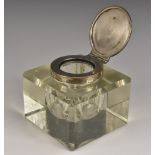 A George V silver mounted clear glass square desk inkwell, hinged cover, 9cm wide, Birmingham c.