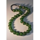 A string of green glass aggry trade beads, the largest 2.