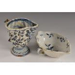 A Delft double-lipped sauceboat, painted in tones of blue and red with leafy sprigs, 20cm wide,