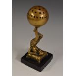 A 19th century bronze novelty, cast as an acrobat balancing a ball on an upturned foot,