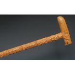 An Indian sandalwood walking cane, L-shaped handle carved with a ferocious lion,