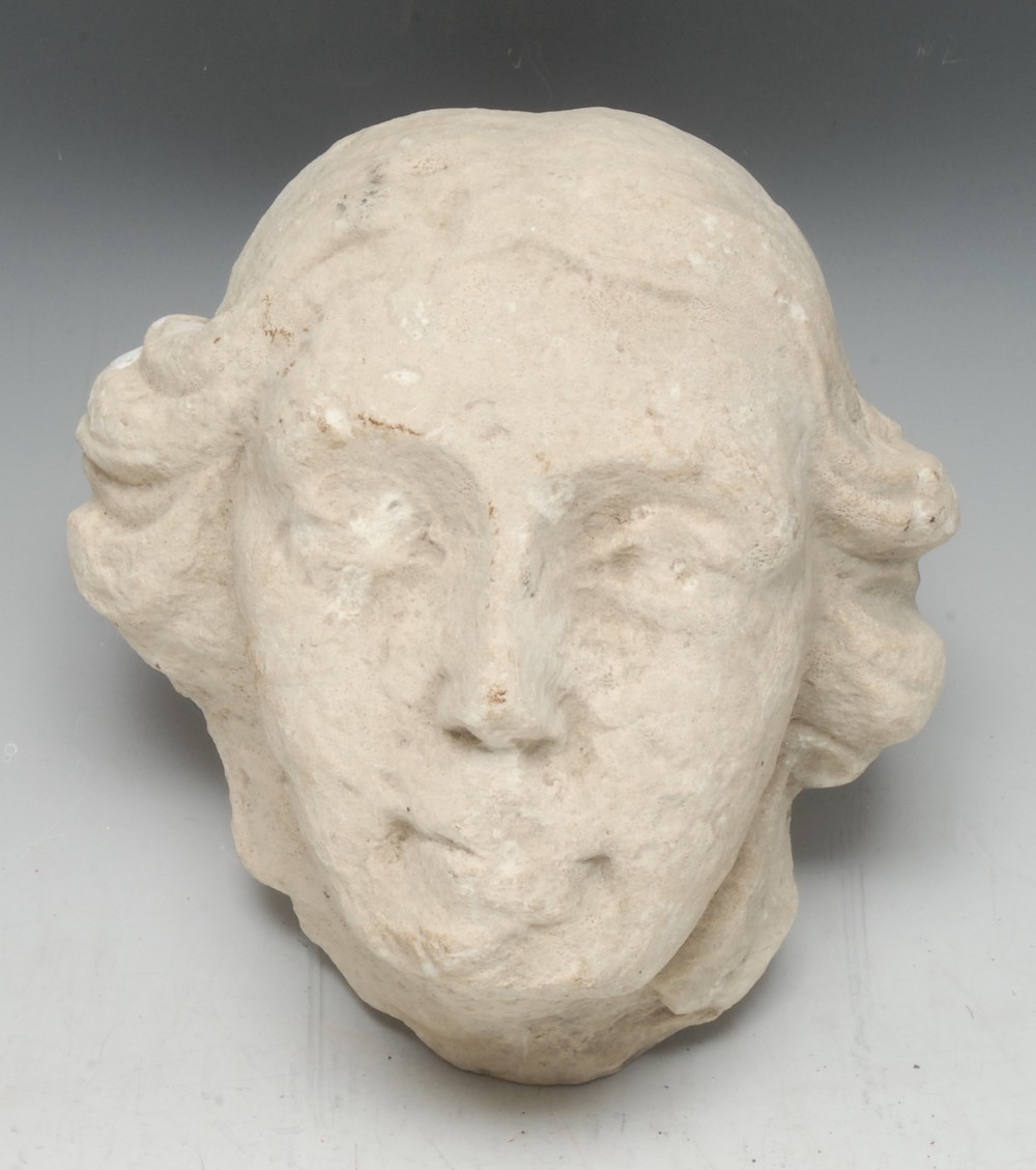 A Medieval limestone sculptural fragment, carved as the head of a man, 20cm high, 19cm wide,