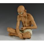 A Royal Dux figure, of Mahatma Gandhi (1869 - 1948), seated cross-legged, 30.