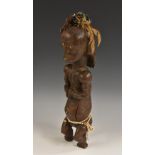 Tribal Art - an African fertility figure, seated on a stool, adorned with feathers and beadwork,