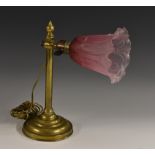 An early 20th century brass adjustable desk lamp, moulded glass shade, momed circular base, 31.