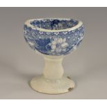 An early 19th century Pearlware eye bath, transfer printed in underglaze blue, knopped stem,