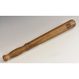 An early 20th century elm police truncheon, branded DC below a coronet, ribbed grip,