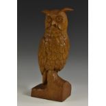 An oak carving, of an owl, perched on a tree stump,