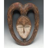 Tribal Art - a Kwele softwood mask, carved in relief and picked out in earth pigments, 47cm long,