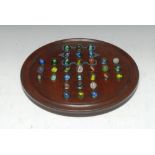A Victorian mahogany solitaire board, the circular field picked out in polychrome for glass marbles,