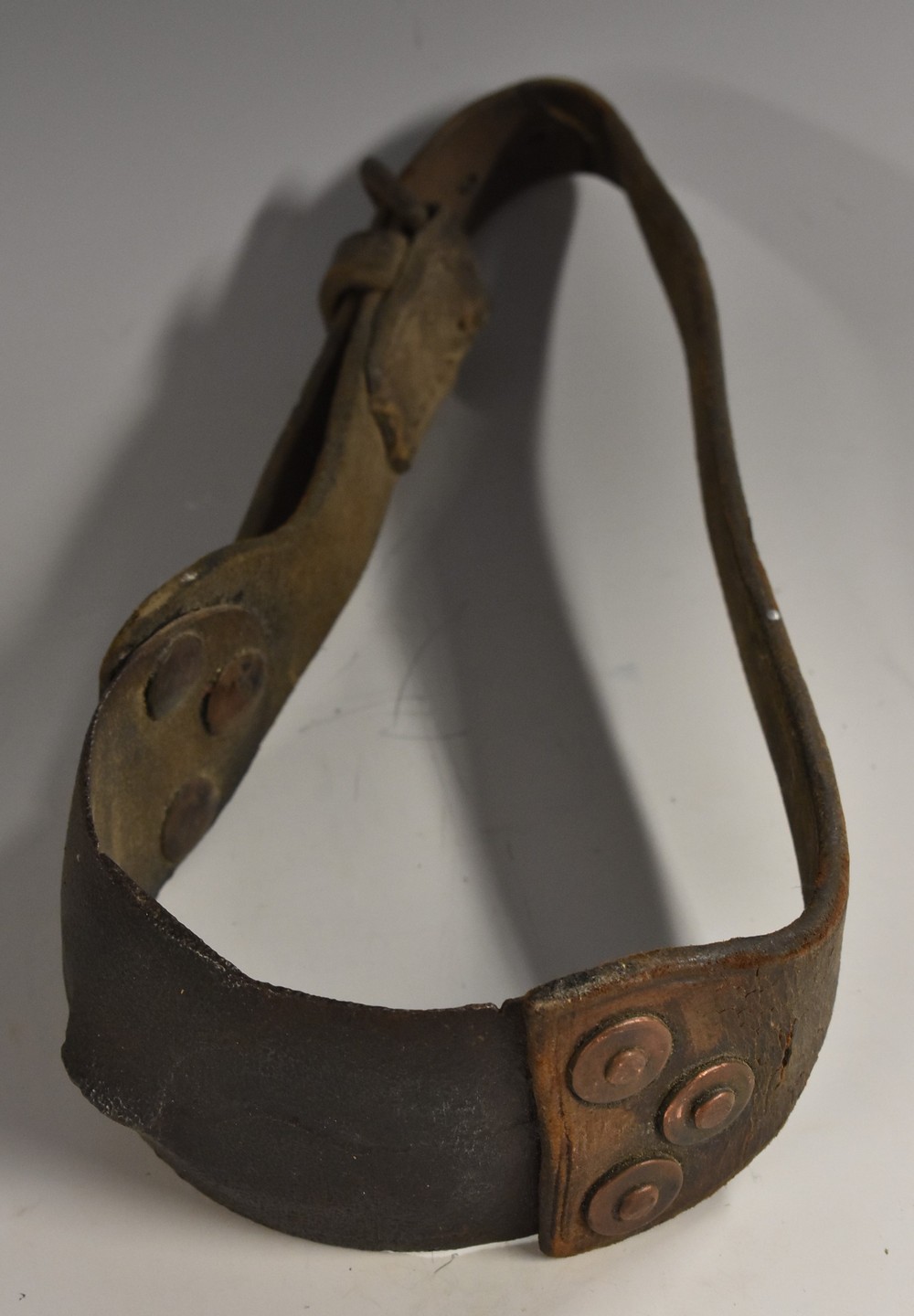 An 18th/19th century iron and leather fighting dog collar, copper-riveted construction,