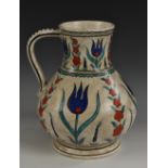 An Iznik design baluster ewer, painted in tones of blue,