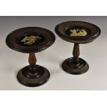 A pair of 19th century South German/Italian softwood and parcel-ebonised table top candle stands,