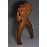 A Black Forest lever-action novelty nutcracker, carved as a bearded man wearing a cap, 20.