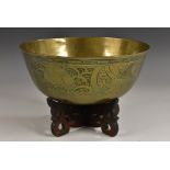 A Chinese brass circular singing bowl, chased with a ferocious dragon and scrolling clouds,