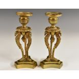 A pair of French Empire gilt bronze tripod mantel sticks, eagle monopodia,