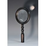 An early 20th century ebony connisseur's magnifying glass, circular lens, turned haft, 25.
