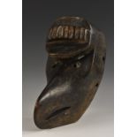 Tribal Art - an African ceremonial mask, probably Chokwe, carved with stylised avian features,