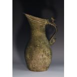 A Middle Eastern Islamic bronze ovoid water ewer, stylised zoomorphic scroll handle, 35.